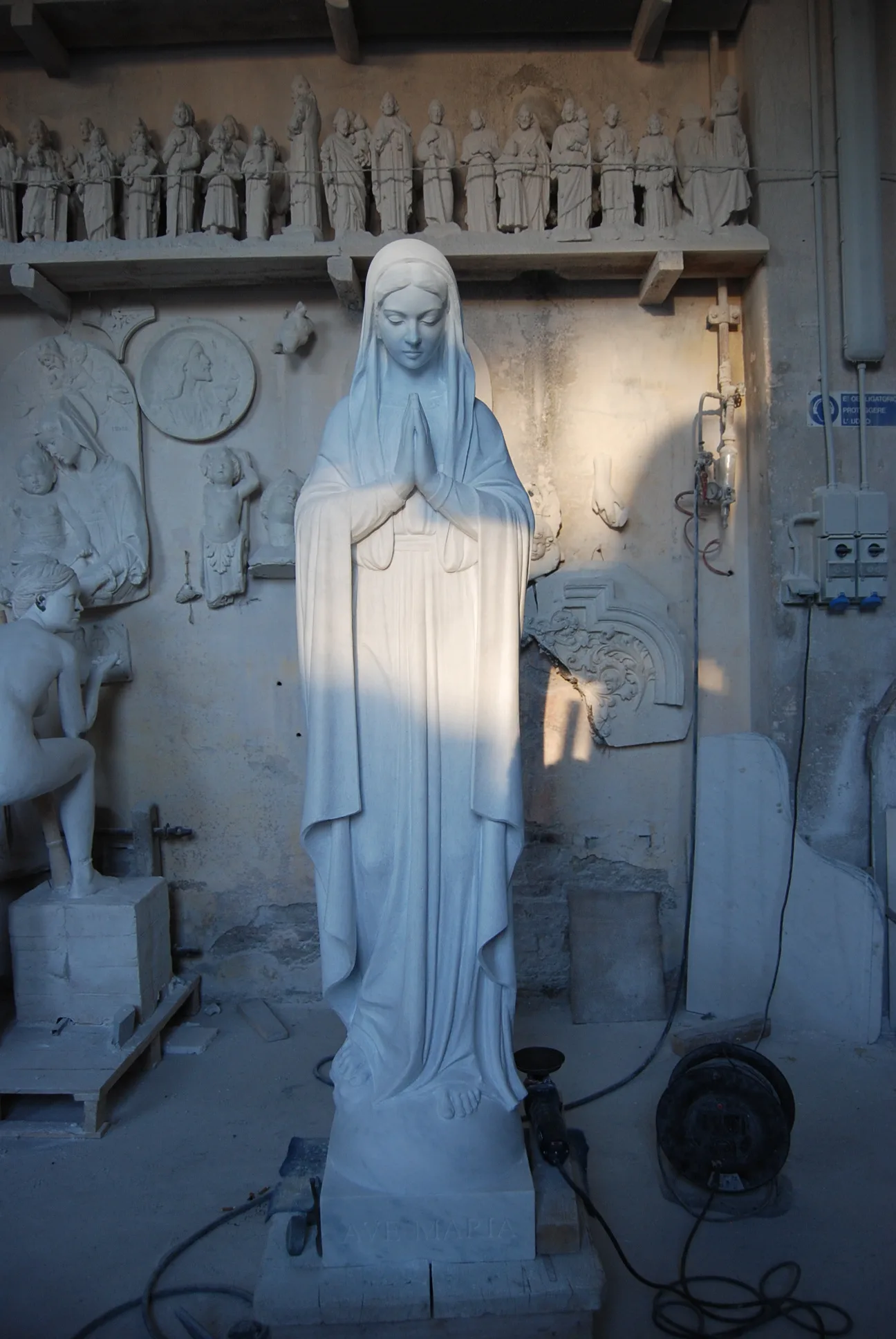 Una Madonna nella luce azzurra del capannone